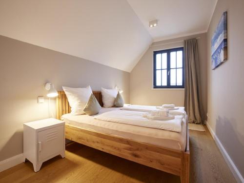 德兰斯克Reetland am Meer - Superior Reetdachvilla mit 2 Schlafzimmern F02的一间卧室设有一张大床和窗户