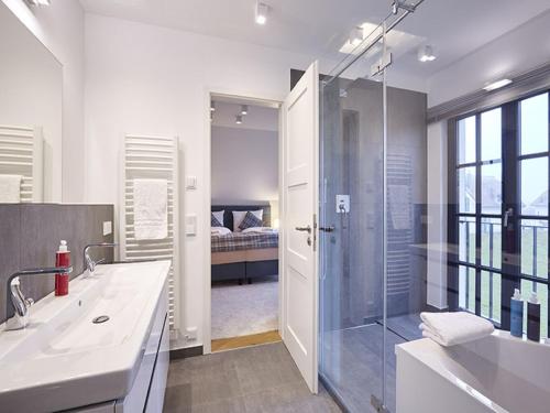 德兰斯克Reetland am Meer - Luxus Reetdachvilla mit 3 Schlafzimmern, Sauna und Kamin F15的带淋浴、盥洗盆和浴缸的浴室