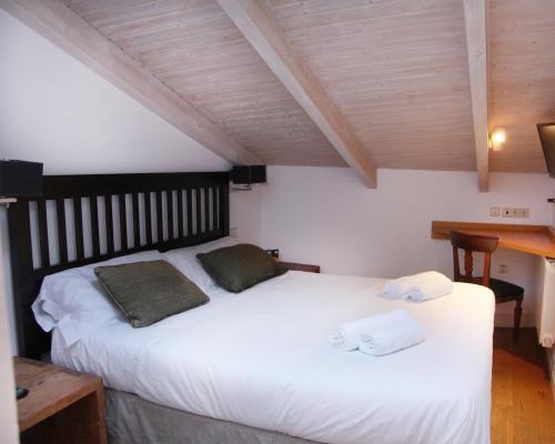 布尔戈斯奎塔米拉普埃布拉酒店的卧室配有白色的床和2条毛巾