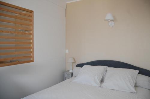 沙特尔LE SEUIL的一间卧室配有一张带白色床单的床和一扇窗户。