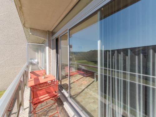 布列登Apartment Residentie Astrid-7 by Interhome的阳台设有滑动玻璃门和红色椅子