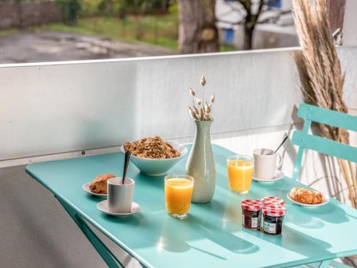卡纳克Apartment Les Pins-3 by Interhome的蓝色桌子,早餐食品和橙汁