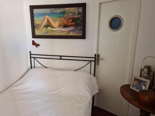 托尔雷莱Village des Sables 500 mètres de la Méditerranée.的卧室配有一张床,墙上挂有绘画作品