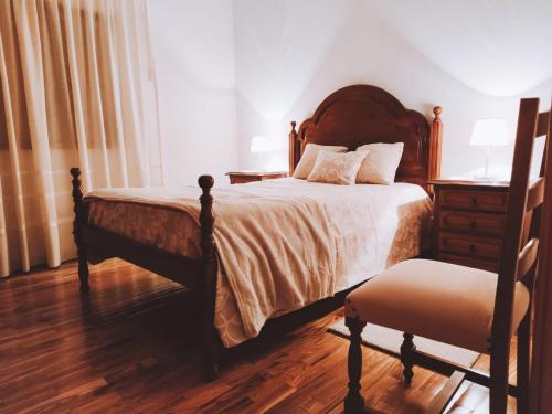 布拉干萨O Palheiro的一间卧室配有一张床、梳妆台和椅子