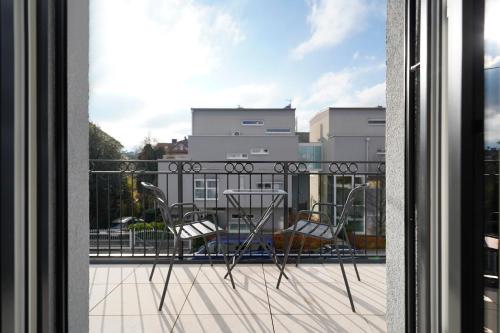 萨尔茨堡numa I Maximilian的阳台配有桌椅,享有风景。