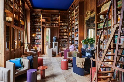圣日耳曼昂莱Maison du Val - Les Maisons de Campagne的图书馆配有椅子和书架