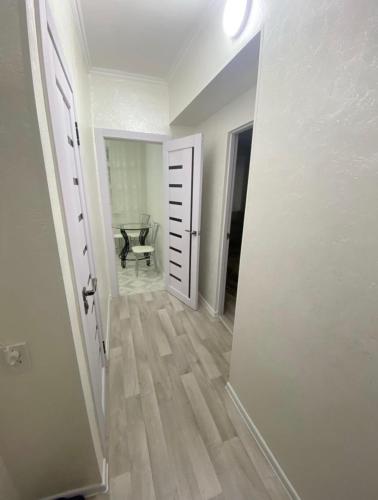 阿拉木图Ахметова 6 7的走廊上设有一扇开放式门,房间内设有一把椅子