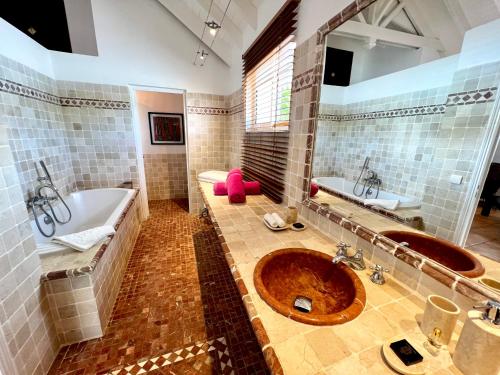 Anse Marcel Villa Privilege的大型浴室设有2个水槽、浴缸和浴缸。