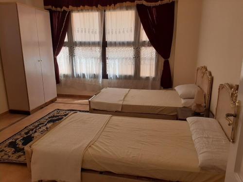 开罗Small Friendly Apart In a Villa - New Cairo 5th Settlement的带窗户的客房内的两张床