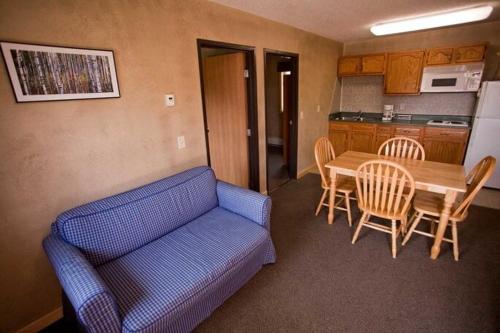 ElyAdventure Inn的客厅配有蓝色的沙发和桌子