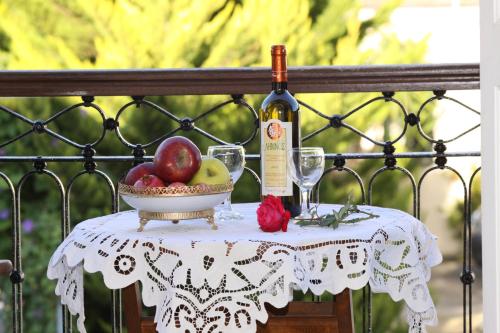米里纳阿蒂米斯传统酒店 的一张桌子,上面放着一碗水果和一瓶葡萄酒
