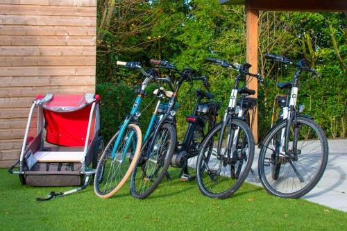 坎珀兰luxe Villa Maroma Regal aan Veerse meer met 4 Ebikes GasBBQ & EV laadpaal的一组自行车彼此停放