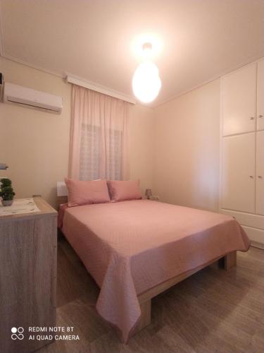 韦瑞洛纳VILLA ALKMINI NEAR THE AIRPORT的一间卧室配有带粉色床单和台灯的床