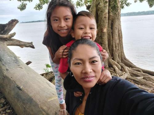 MoreliaHospedaje KOWAPANA BOCAS DE AMACAYACU的两个女孩和一个站在水边的妇女