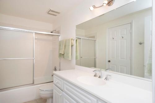 乔治敦Dive into Sunsets at The Residences的白色的浴室设有水槽和卫生间。