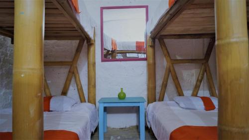 波哥大利马利蒙烛火旅馆的客房设有两张床和一张蓝色的桌子。