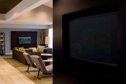 布卡拉顿Sonesta Select Boca Raton Town Center的带电视的客厅和带沙发的客厅。