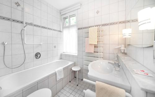 布格贝恩海姆瓦尔德加斯托弗维尔德巴德酒店的白色的浴室设有浴缸和水槽。