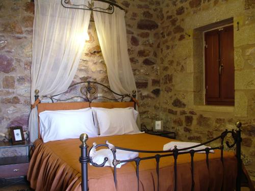 斯科达利昂Xenonas Thalis的卧室配有一张石墙床