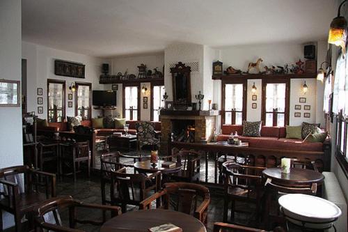 马克里尼撒佩特里诺酒店的一间带桌椅和壁炉的餐厅