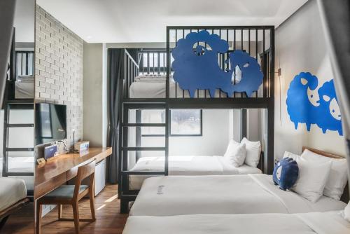 曼谷曼谷素里翁可可特尔酒店的一间卧室配有两张双层床和一张书桌