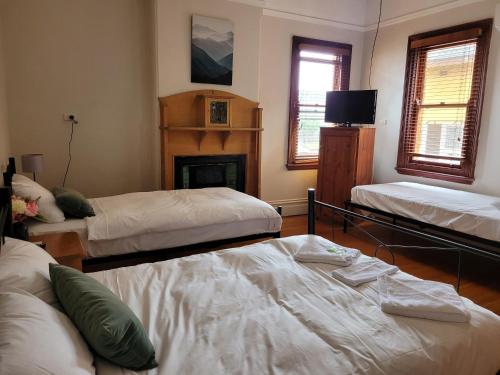 悉尼伯伍德住宿加早餐酒店的客厅设有两张床和壁炉