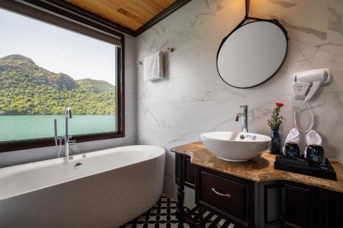 下龙湾La Casta Regal Cruise的带浴缸、水槽和窗户的浴室