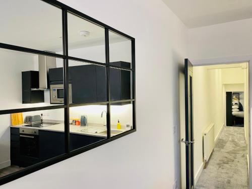 莫克姆Eden Retreats Serviced Apartments的厨房配有黑色橱柜和墙上的镜子