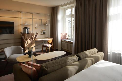 苏黎世索丽尔苏黎伯格酒店的带沙发的客厅和用餐室
