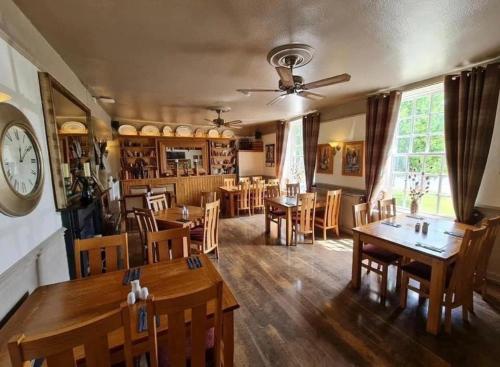 Frampton on Severn贝尔酒店的一间带桌椅和时钟的用餐室