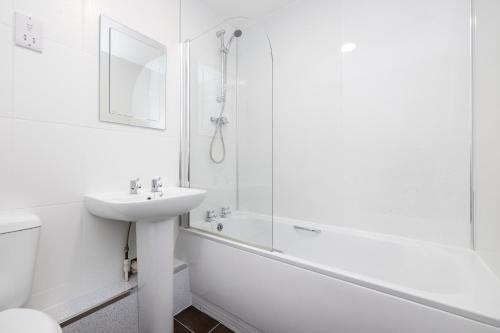 格拉斯哥JOIVY Bright 3-bed flat overlooking The Clyde的白色的浴室设有水槽和淋浴。