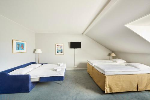 罗斯基勒Zleep Hotel Prindsen Roskilde的阁楼间设有两张床和电视。