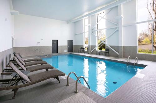 魁北克市Quality Inn的一个带椅子和大窗户的大型游泳池