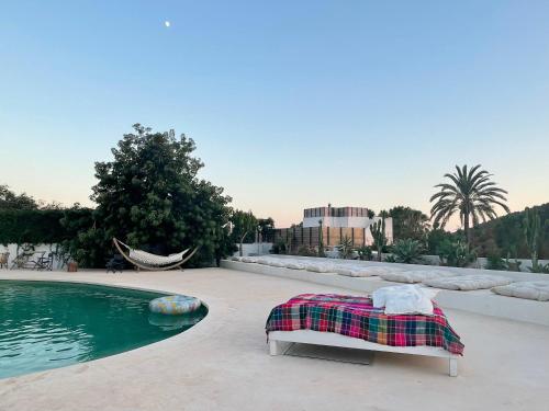 Sant Francesc de s'EstanyLa Pandilla Ibiza的游泳池畔的一张床