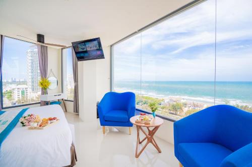 头顿Annata Beach Hotel的一间卧室设有一张床和两把椅子,享有海景