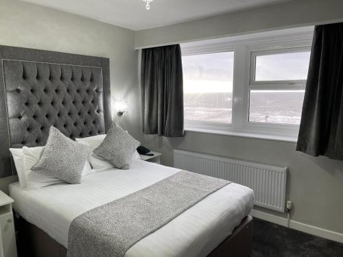 布莱克浦公园别墅酒店的一间卧室设有一张大床和一个窗户。