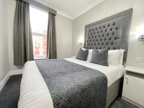 布莱克浦公园别墅酒店的一间卧室设有一张大床和一个窗户。