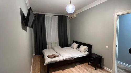 里加里加公寓式酒店的一间小卧室,配有一张床和一台平面电视