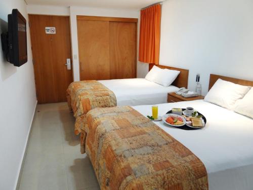 坎昆盖比套房酒店的酒店客房设有两张床和一盘食物