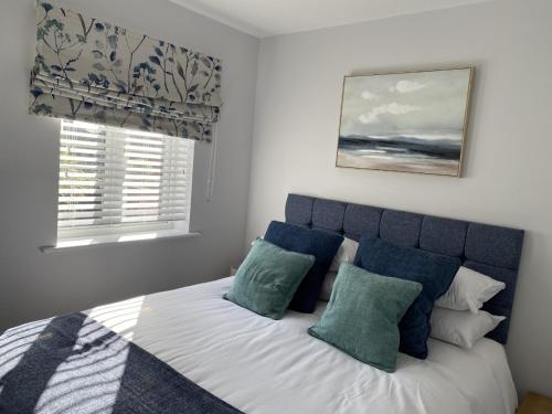 亨斯坦顿The Sorting House的一间卧室配有一张带蓝色和白色枕头的床