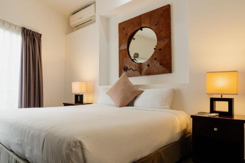 普拉亚卡门Almarea Vacation Condo的一间卧室配有一张大床和镜子
