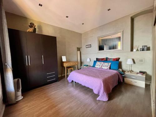 卡普戴尔异国花园公寓酒店的一间卧室配有一张带紫色床罩的床