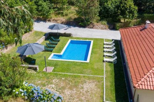 LamelasCasa do Pioledo Camélias de Basto的享有后院的空中景致,设有游泳池和遮阳伞
