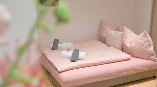 维也纳Ane Apartment的粉红色的床和镜子内的枕头