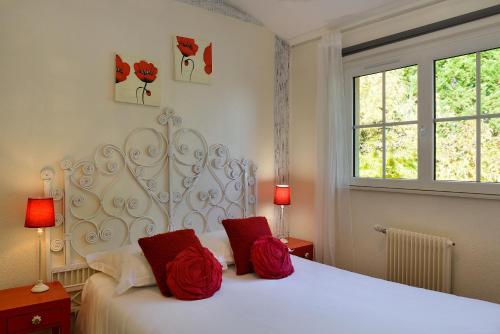 Soings-en-SologneLogis Hôtel Restaurant LE VIEUX FUSIL的卧室配有白色床和2个红色枕头