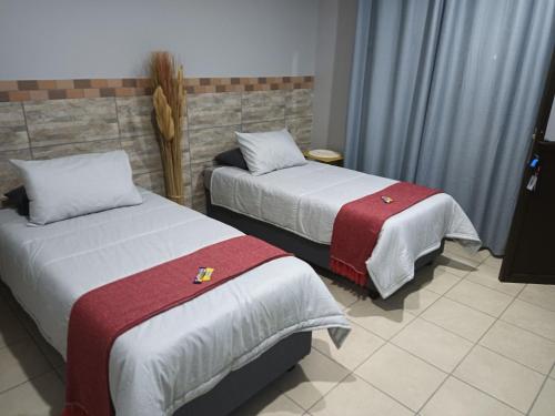 NorthamBig D Accommodation & guesthouse的酒店客房,配有两张带红白毯子的床