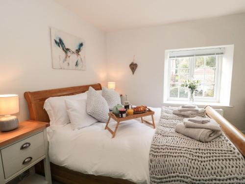 阿克斯明斯特Jasmine Cottage的一间卧室配有一张带桌子和窗户的床