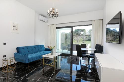 古维亚Rans Luxury Villas & Suites in Corfu with swimming pool的客厅配有蓝色的沙发和桌子