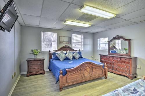 代托纳海滩Serene Daytona Beach House with Private Yard!的一间卧室配有一张带蓝色床单和镜子的床