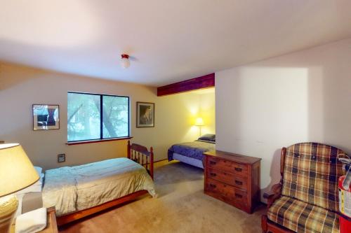 西优胜美地Forest Glen的一间卧室配有两张床和椅子